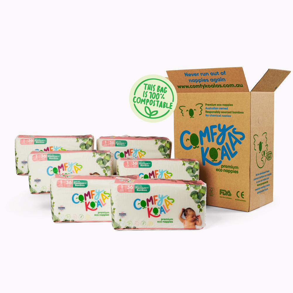 Comfy Koalas eco nappies with compostable packaging in front of an open cardboard box.